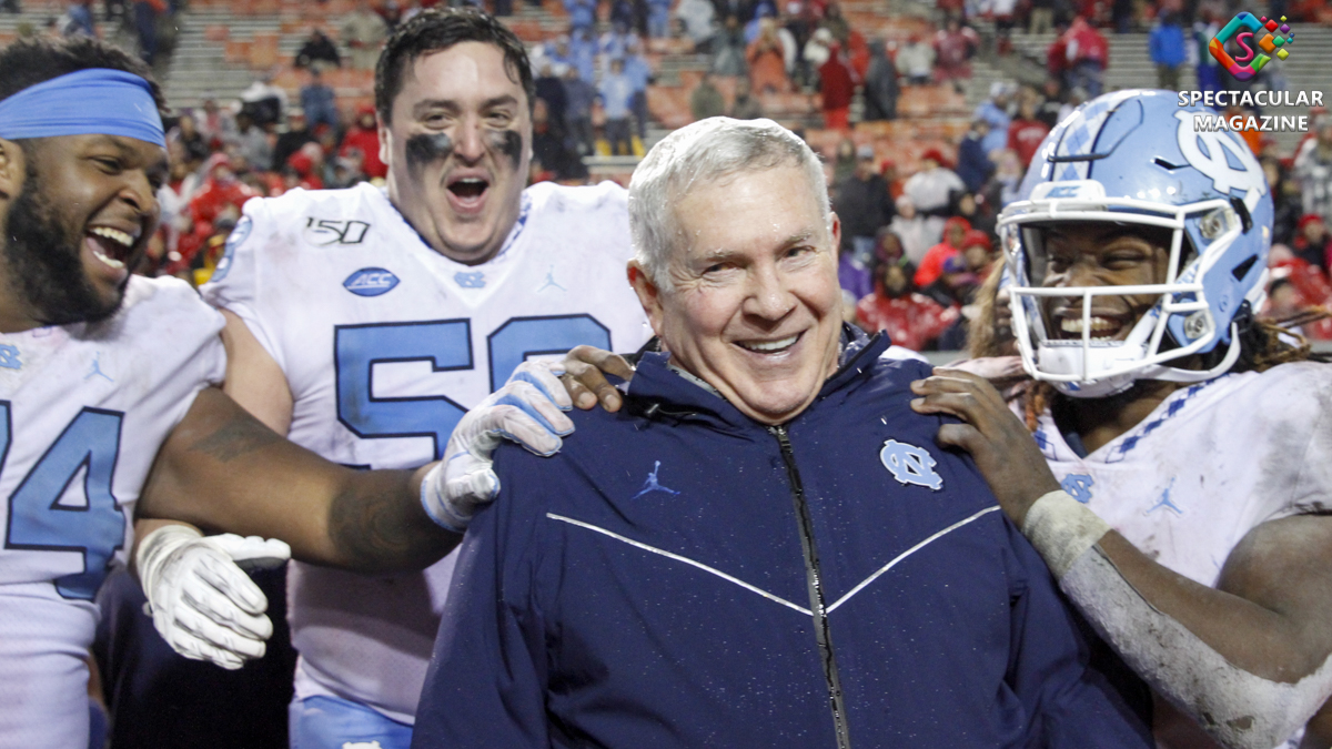 North Carolina football players contgratulate head coach Mack Brown after they dumpedd a bucket of water on him in the final seconds against the N.C. State Wolfpack at Carter-Finley Stadium in Raleigh, N.C., on Saturday, Nov. 30, 2019. UNC (6-6, 4-4 ACC) defeated NCST (4-4, 1-7 ACC) 41-10 to become bowl-eligle in Brown's first year back as a head coach and the first time since 2016. They also defeated their rivals for the first time since 2015.