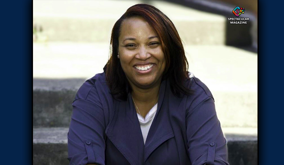 re-election,Dedreana Freeman seated on outdoor steps, smiling and dressed in a blue suit.