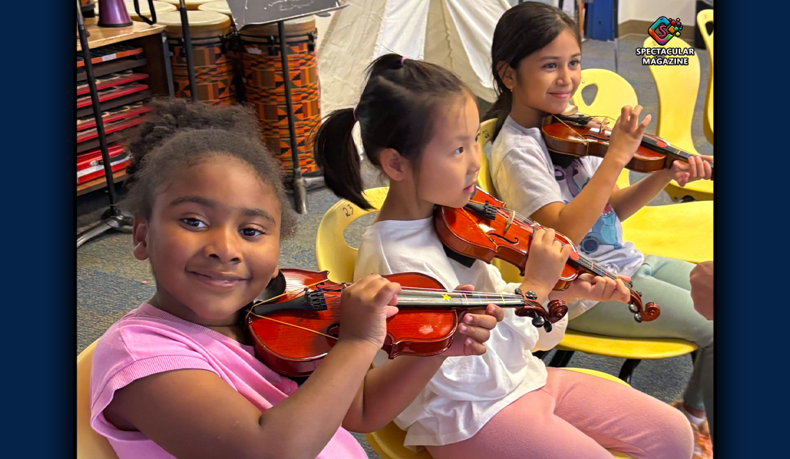 Children learning violin and piano in a small music classroom as part of Kidznotes Saturday Academy in Durham.
