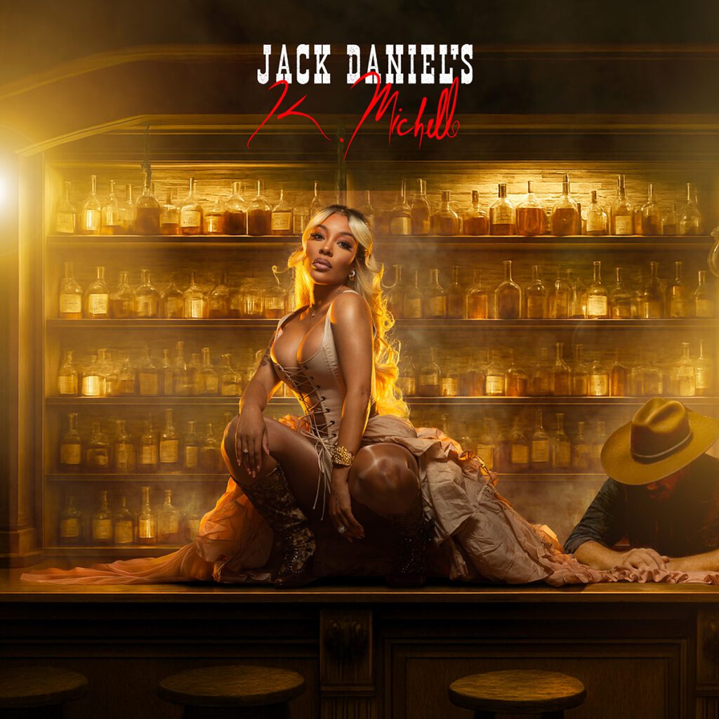 K. Michelle poses in a whiskey bar setting for her country debut “Jack Daniel’s,” marking her historic partnership with the brand.
