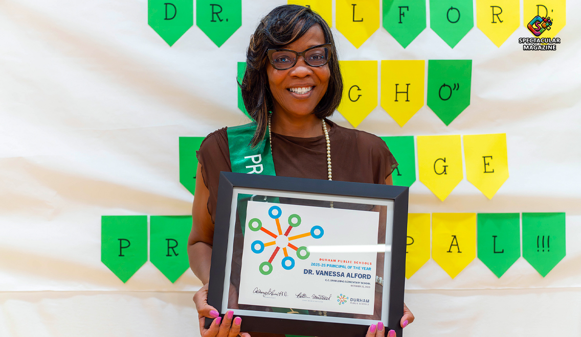 Dr. Vanessa Alford, principal of C.C. Spaulding Elementary School, smiles while holding her 2025-26 Durham Public Schools Principal of the Year award during the district celebration.
