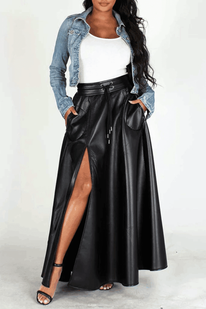 Model wearing high-waist black vegan leather maxi skirt with thigh-high slit and denim jacket.