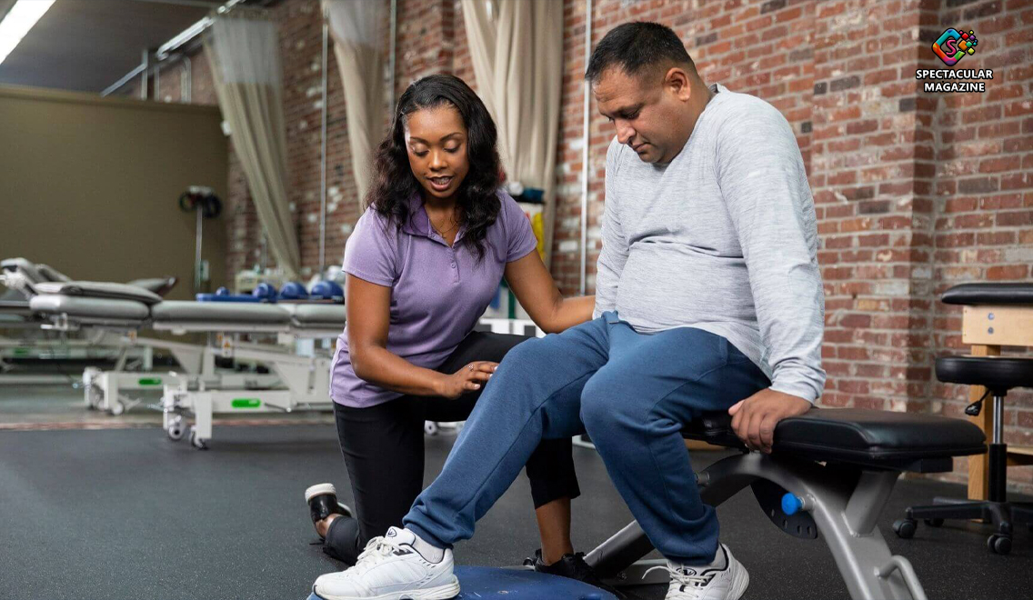 A physical therapy student assists a patient during knee mobility training in a clinical lab, demonstrating hands-on learning in PT school