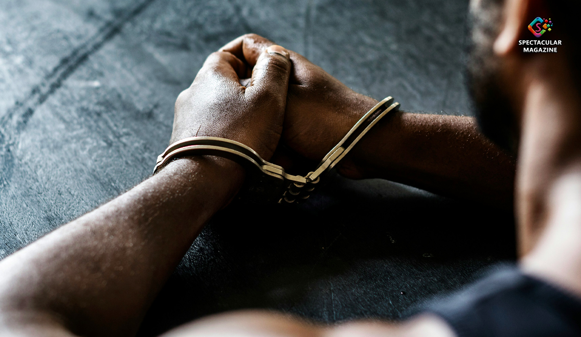 Close-up of an African American man’s hands in silver handcuffs resting on a dark table, symbolizing arrest and conviction in a federal meth drug case.
