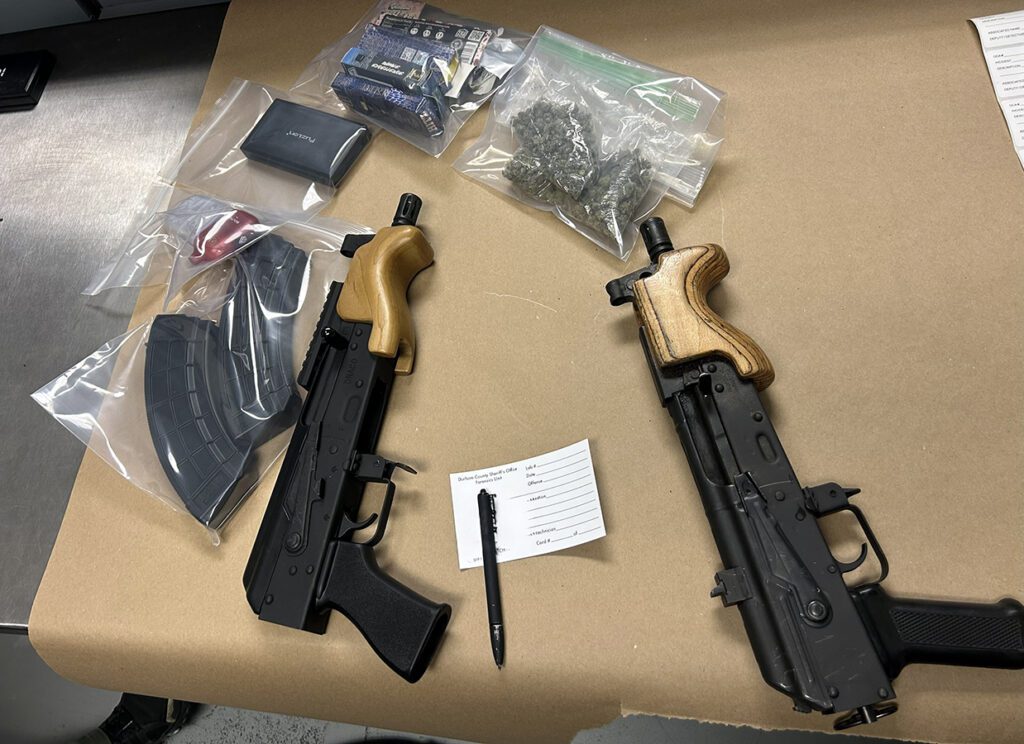 Two semi-automatic Draco handguns, ammunition, and bags of suspected marijuana displayed on an evidence table after a Durham County Sheriff’s Office traffic stop on Dec. 5, 2025.