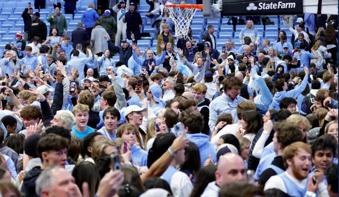 North Carolina fans rush the court and punched Duke staffers at the Dean Smith Center after a last-second win over Duke in a heated ACC rivalry game.