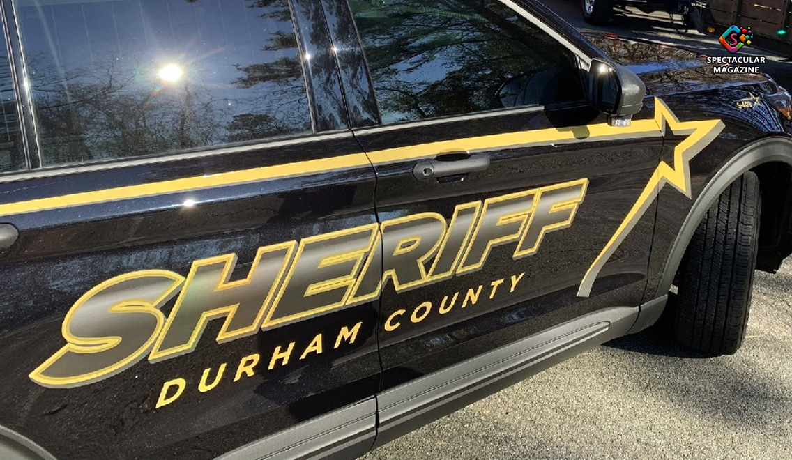 Durham County sheriff deputies investigate the shooting of a possible rap group member outside Carlie C’s grocery store with police tape and vehicles.