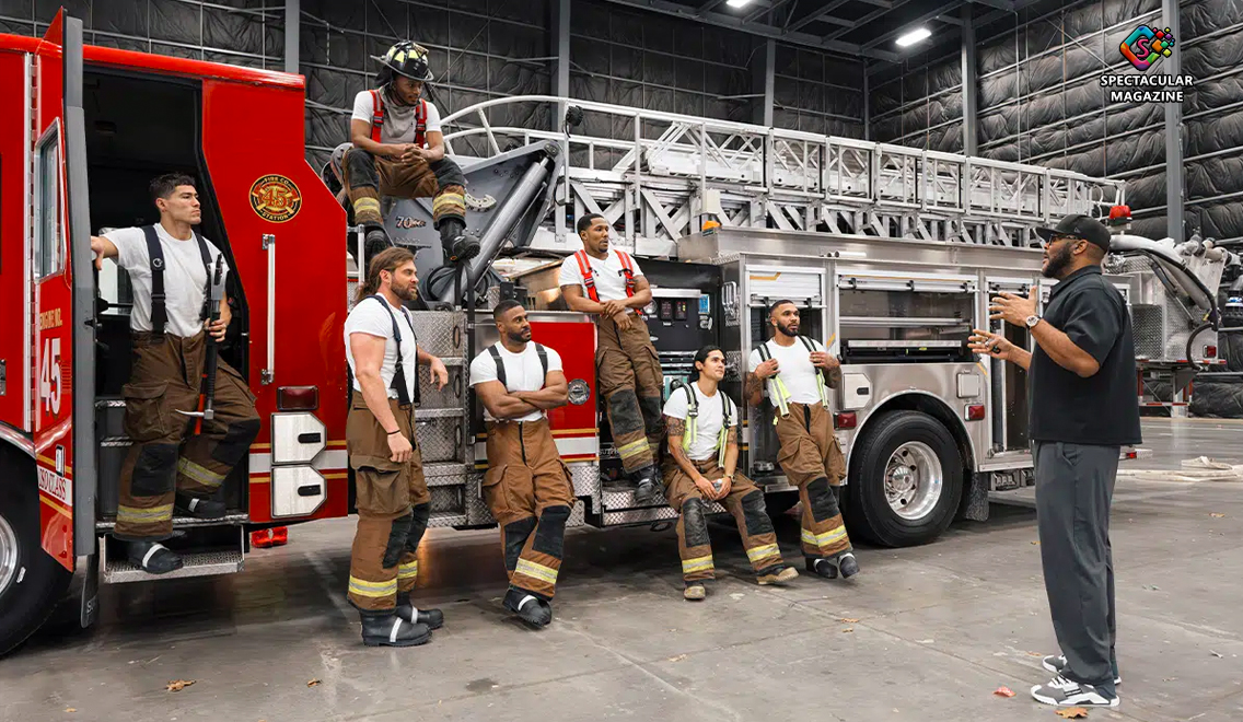 Actors portraying firefighters sit and stand on a fire truck during filming of Tyler Perry Netflix series Where There’s Smoke.